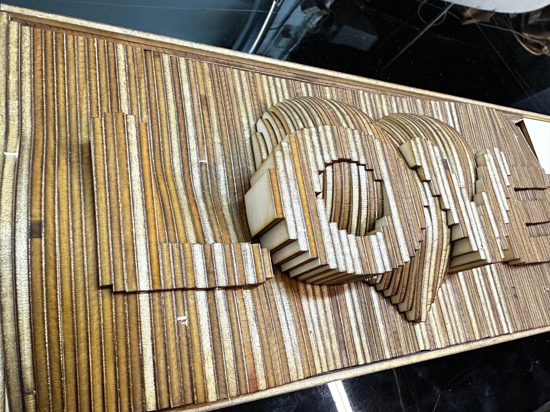 A wooden sculpture of a fish is sitting on a table.