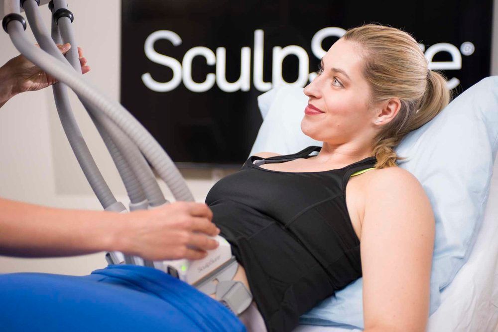 A woman is laying in a hospital bed getting an ultrasound.