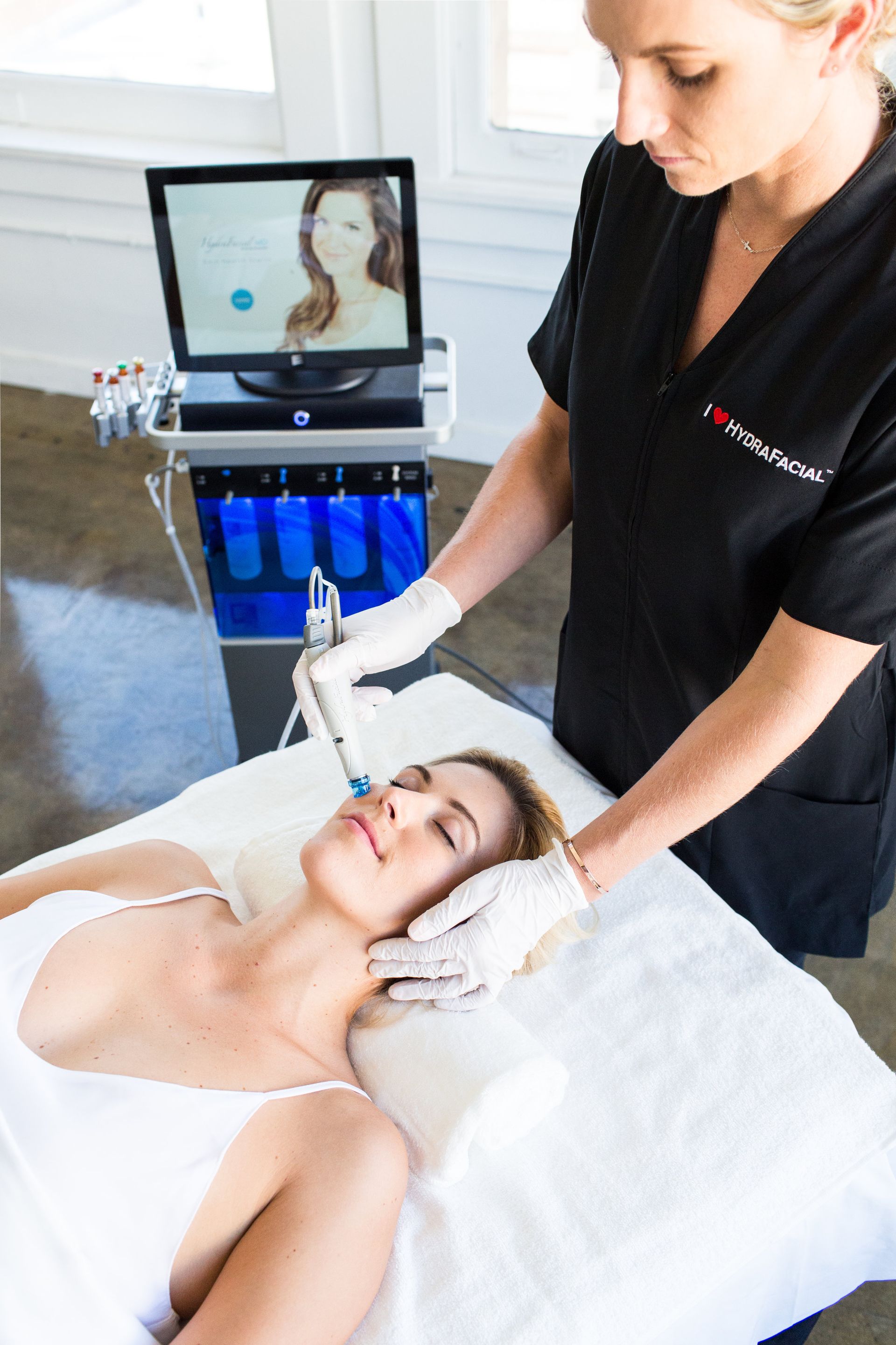 A woman is laying on a bed getting a facial treatment.