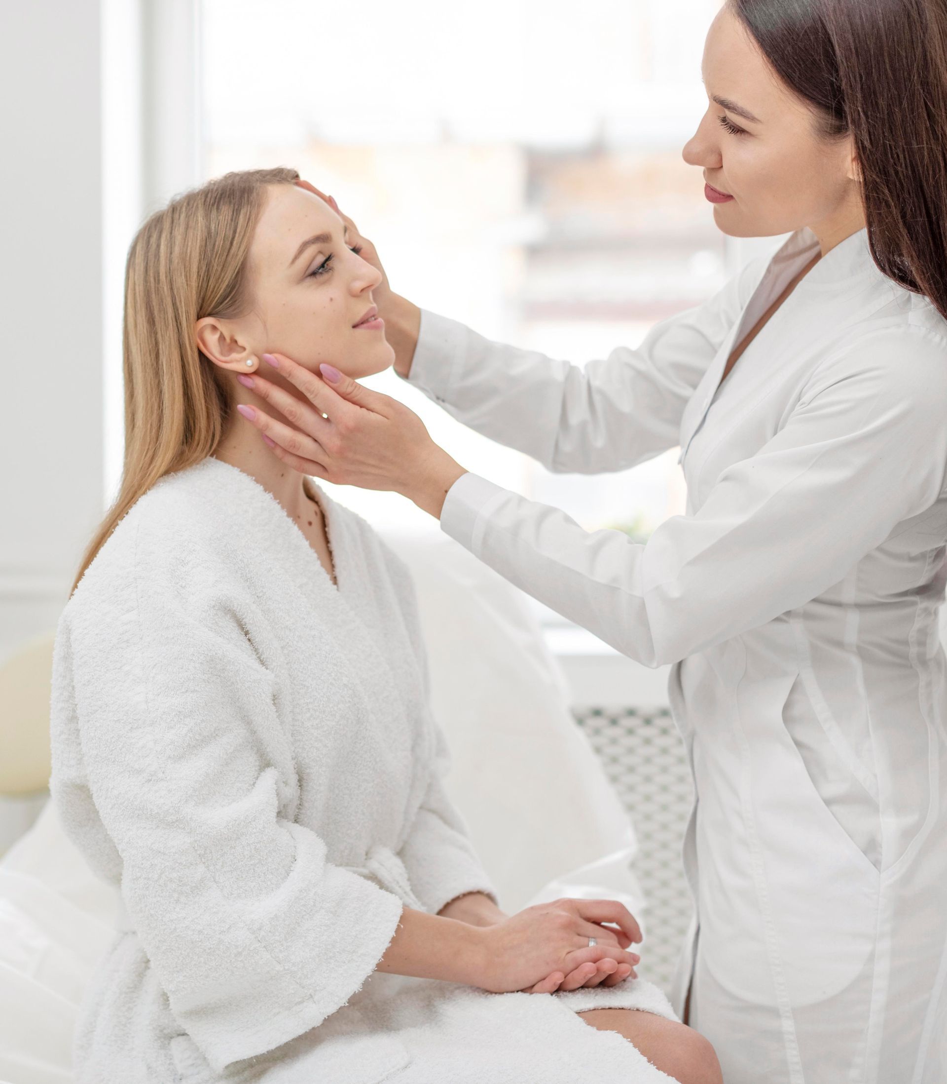 A woman is getting her face examined by a doctor.