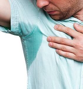 A man is holding his sweaty armpit with his hand.