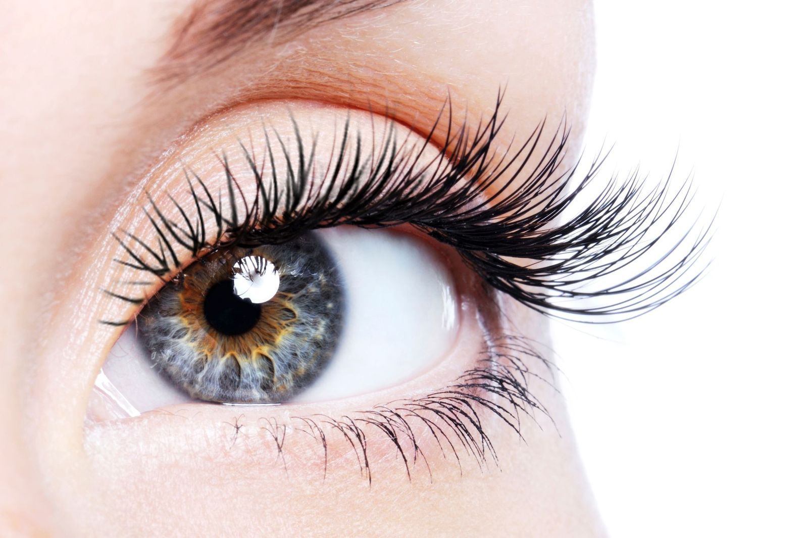 A close up of a woman 's eye with long eyelashes.