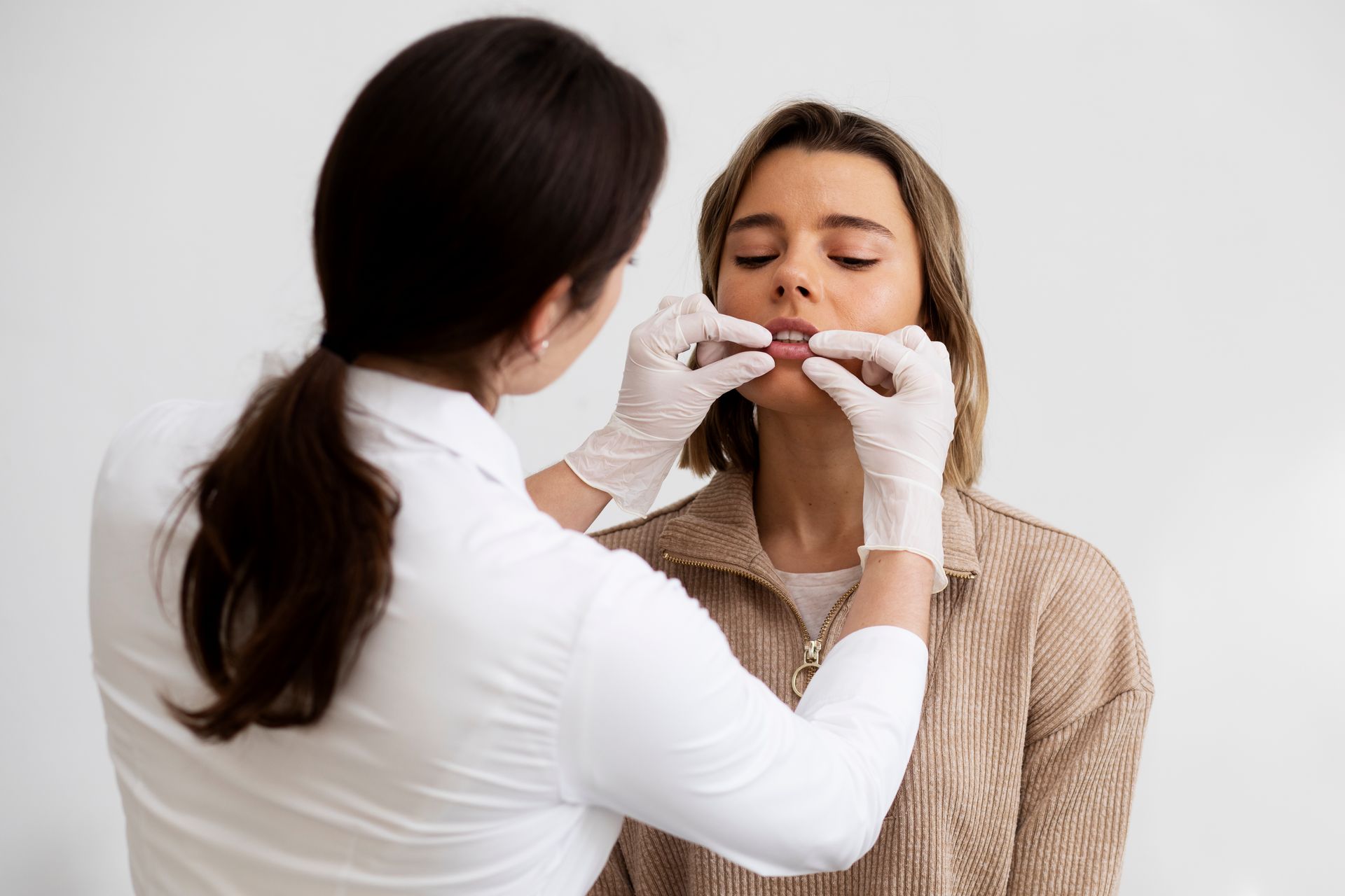 A woman is getting her lips examined by a doctor.