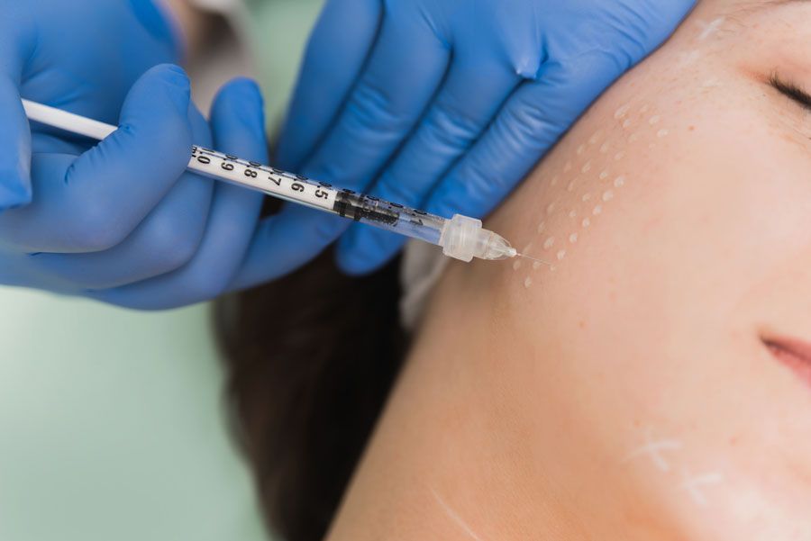A woman is getting a botox injection in her face.