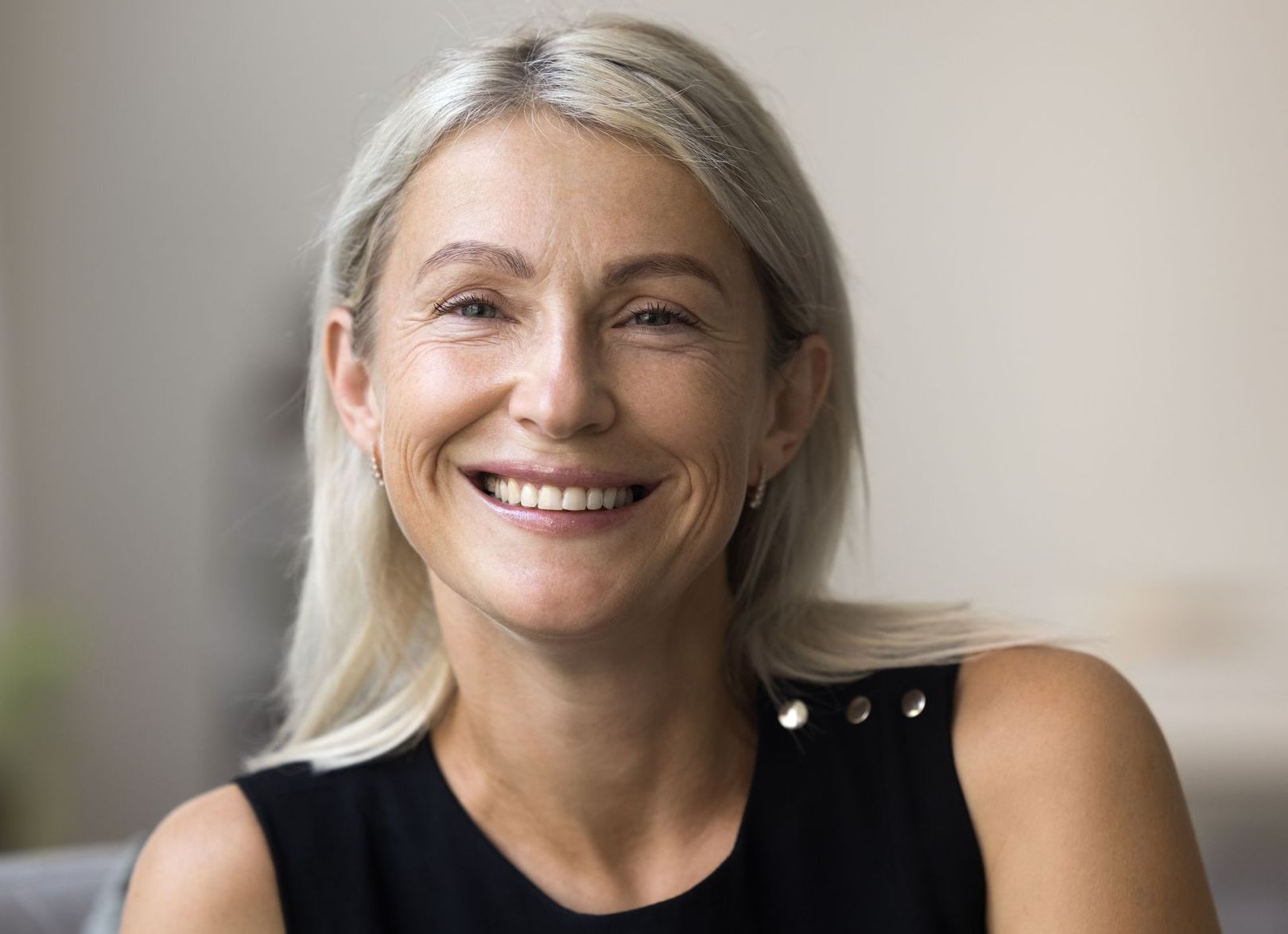 A woman is smiling for the camera while sitting on a couch.