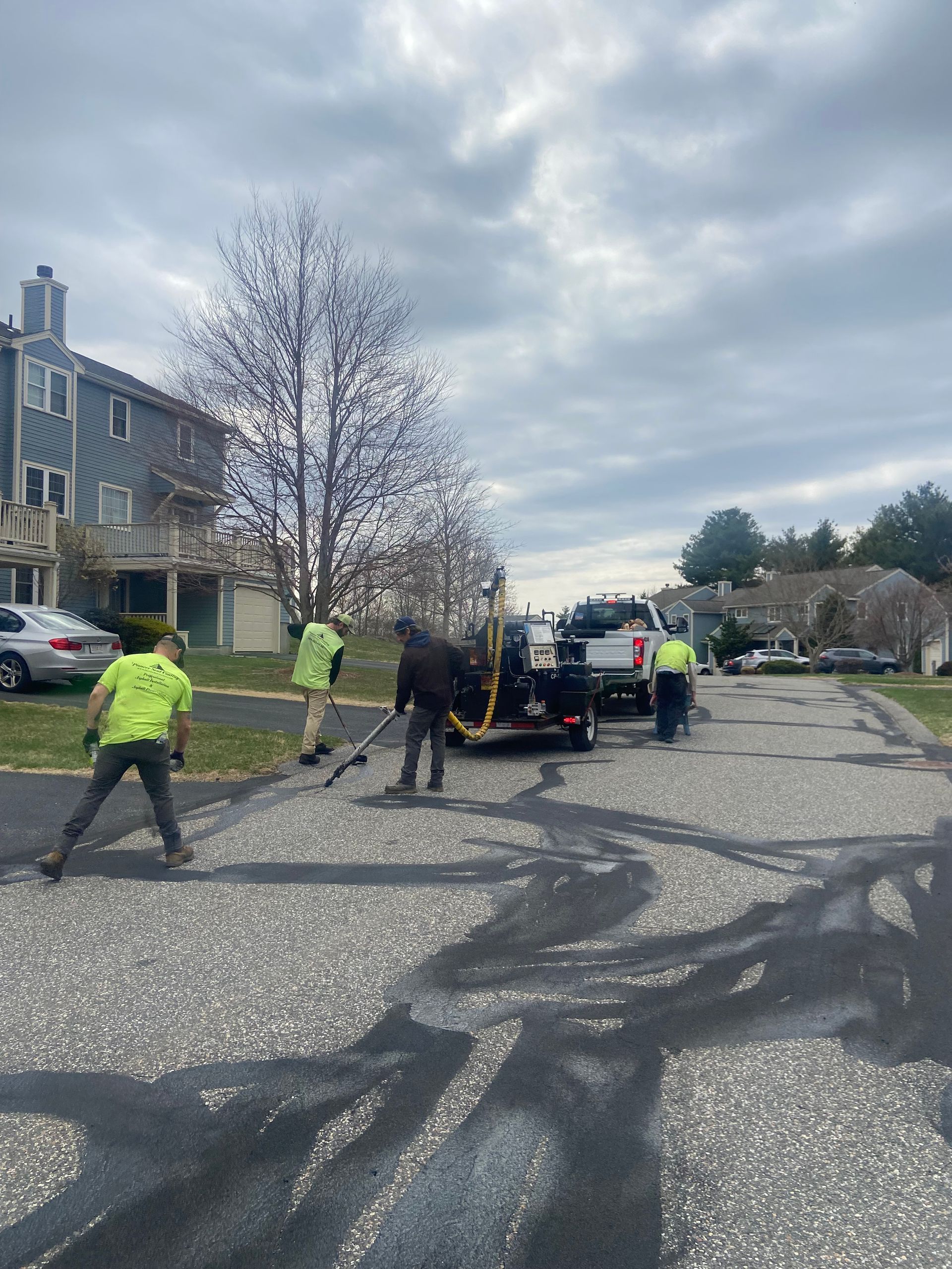 A group of people are working on a driveway.