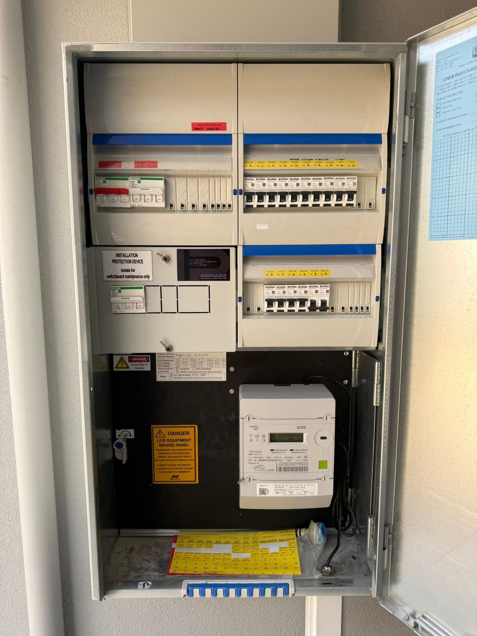 Electric meter box with various breakers and a digital meter. Located on a wall.