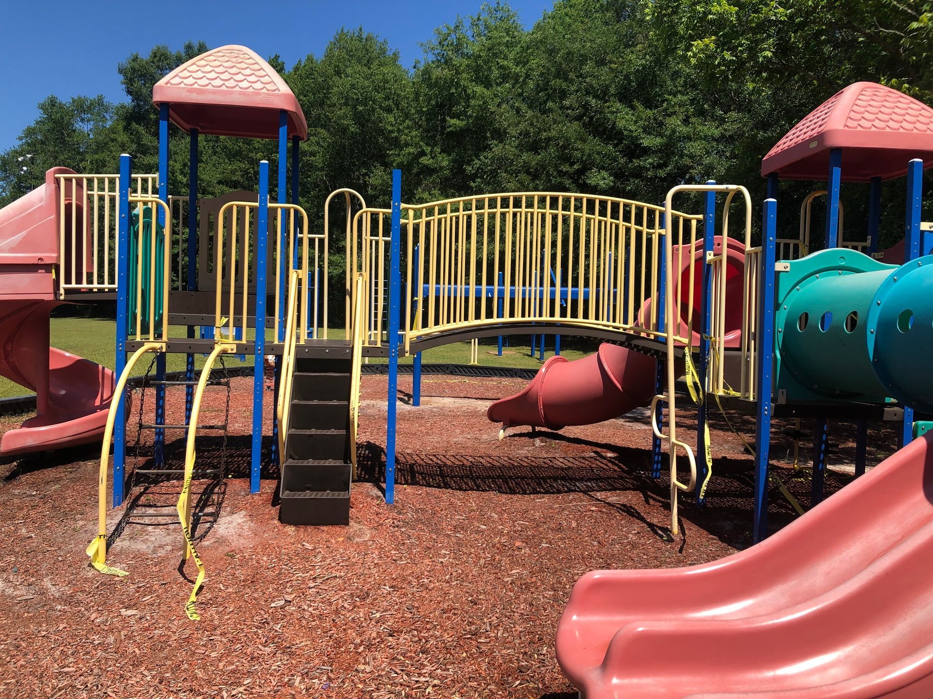 A playground with a lot of slides and a bridge.