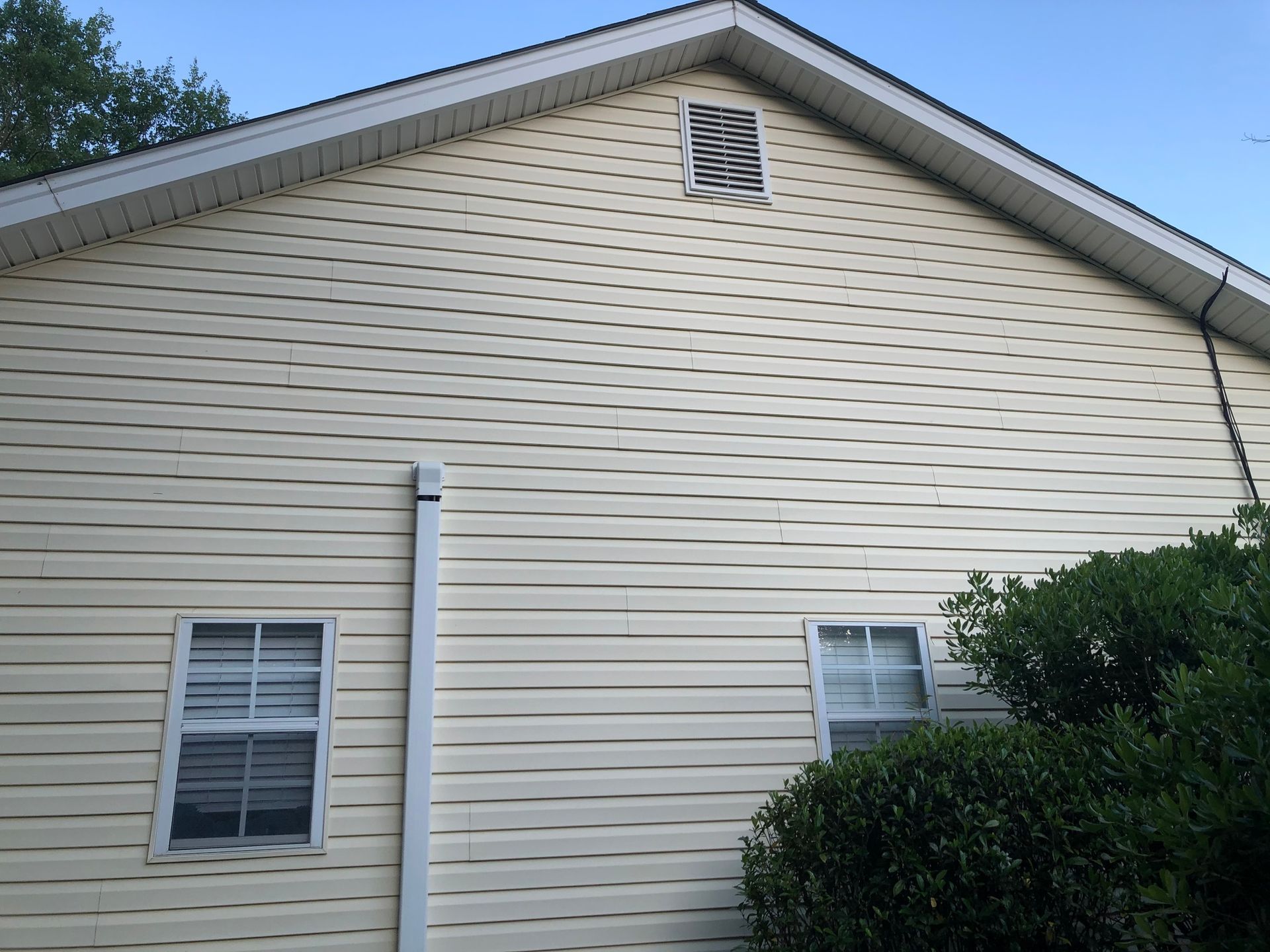 A house with a white siding and two windows