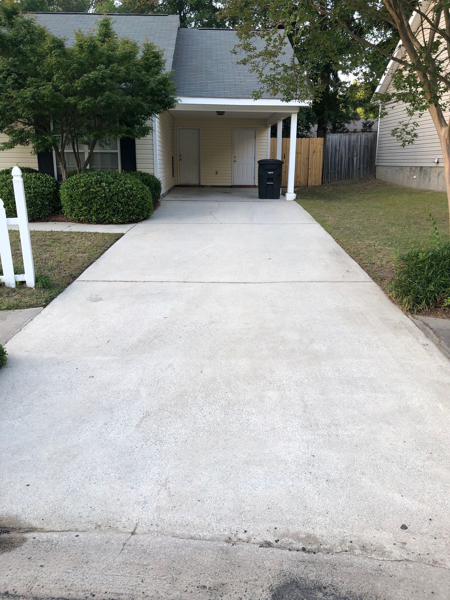 A concrete driveway leading to a house with a garage.