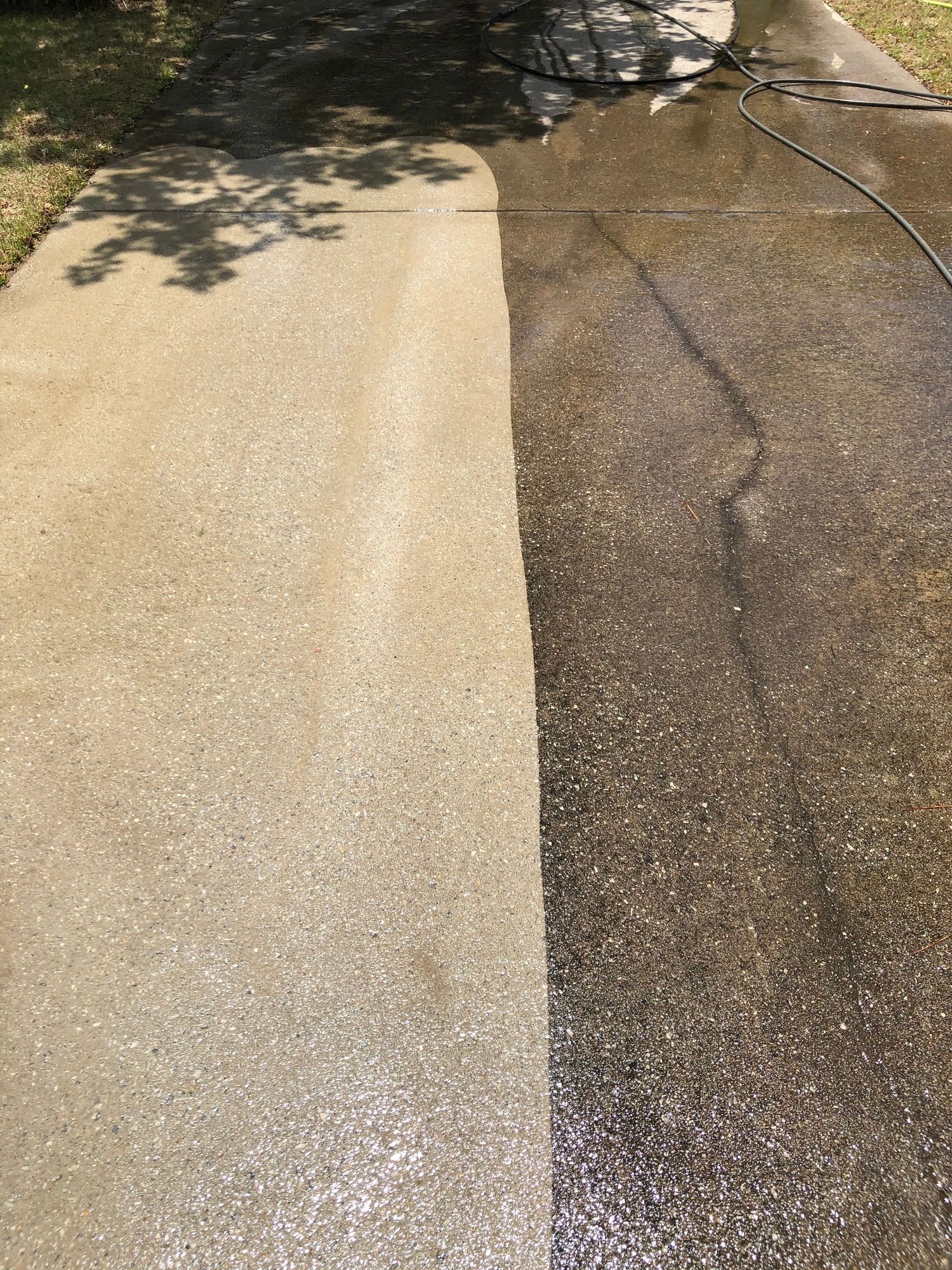A before and after picture of a concrete sidewalk being cleaned with a pressure washer.