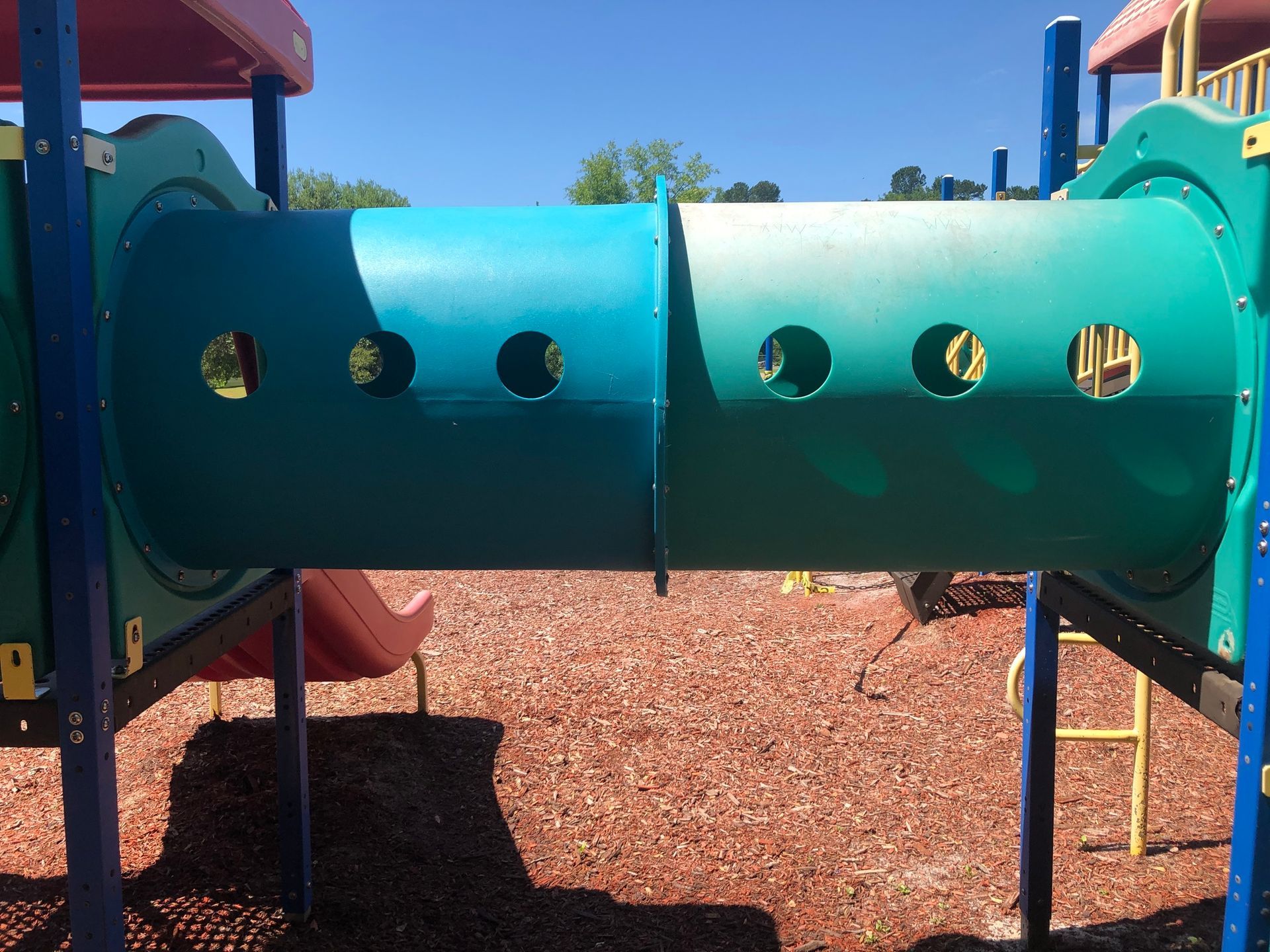 A playground with a blue tunnel with holes in it