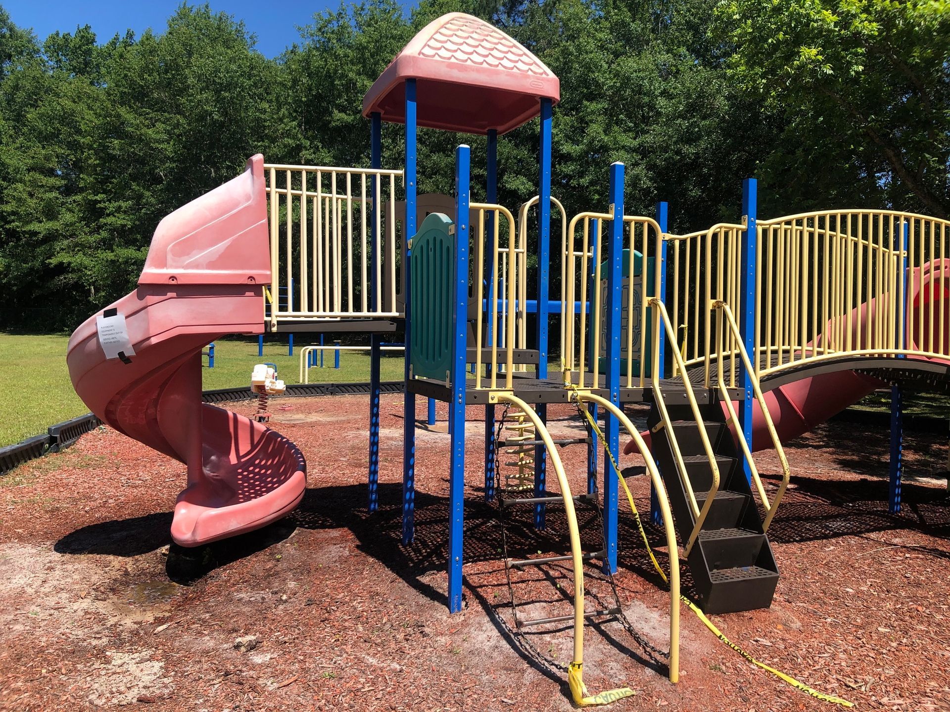 A playground with a slide , stairs , and a bridge.