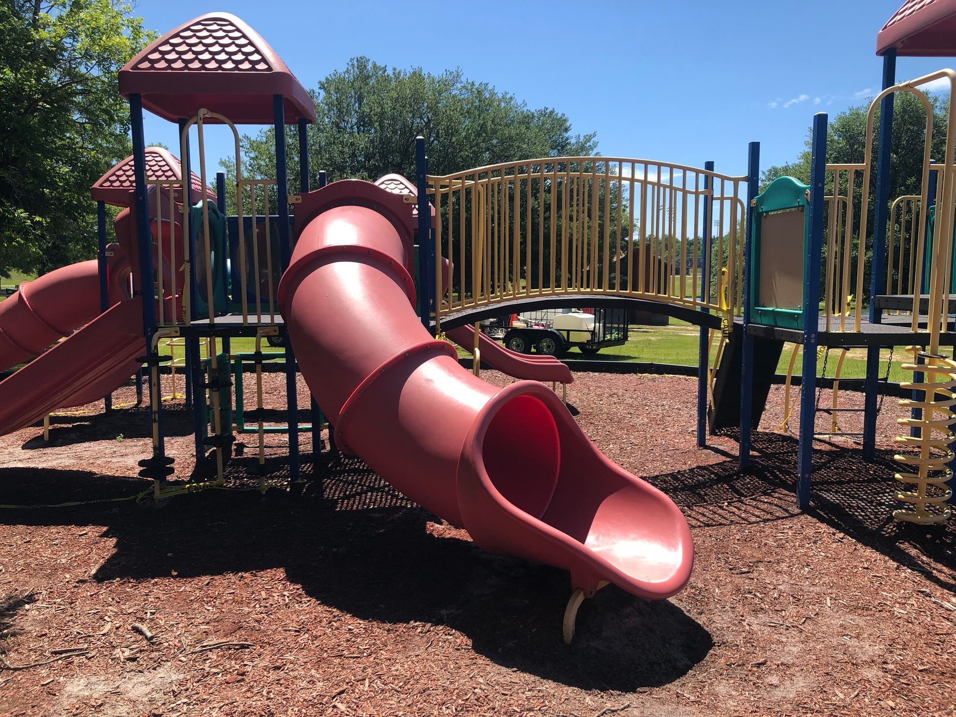 A red slide is in the middle of a playground