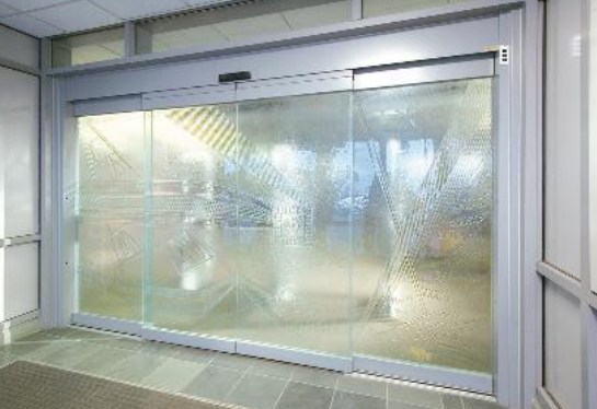 Automatic sliding glass doors with frosted glass panels in a building entrance.