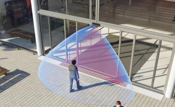 Person approaching automated door; blue and red sensor zones highlight detection areas.