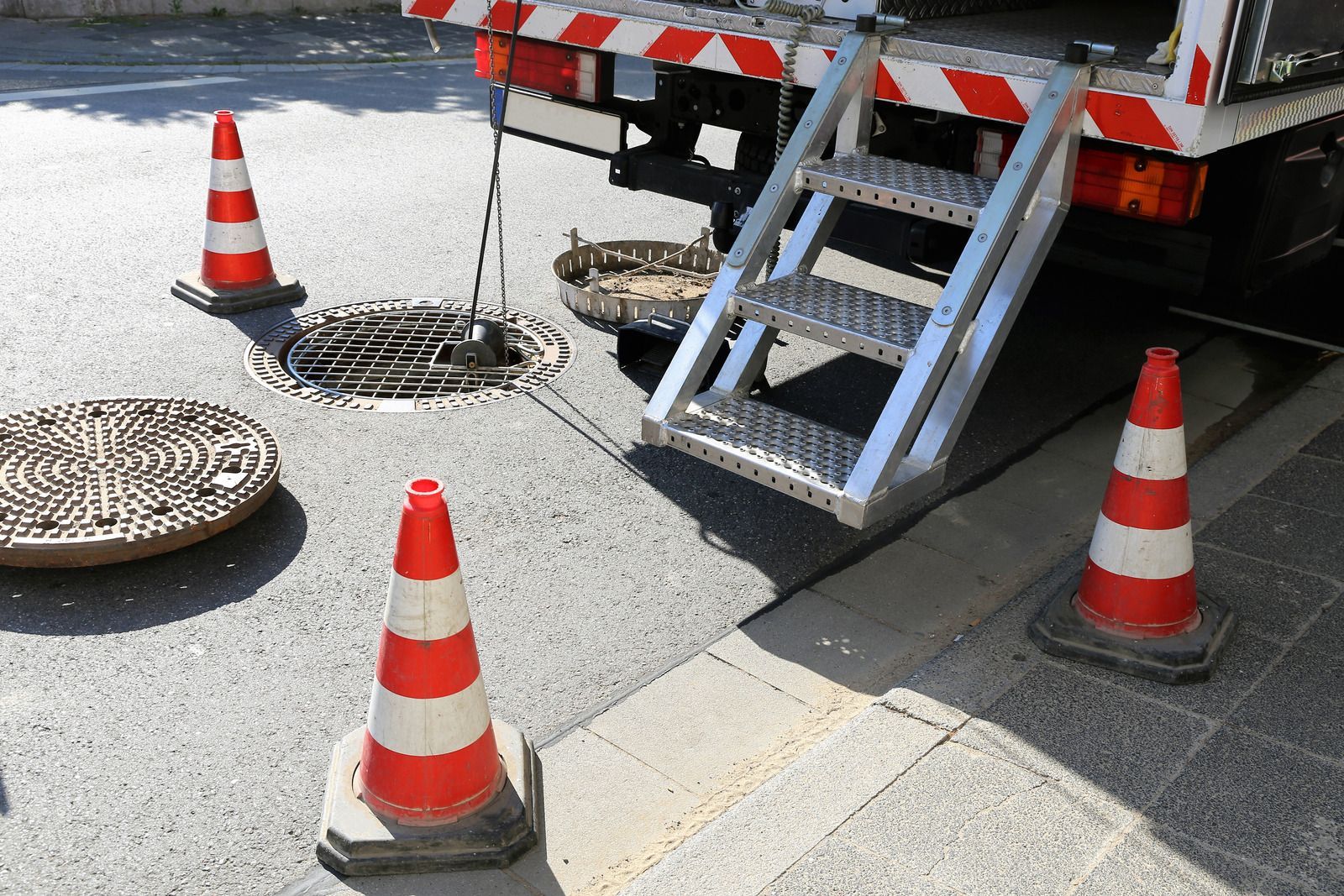 Person in orange shirt uses a tool to examine something in water.