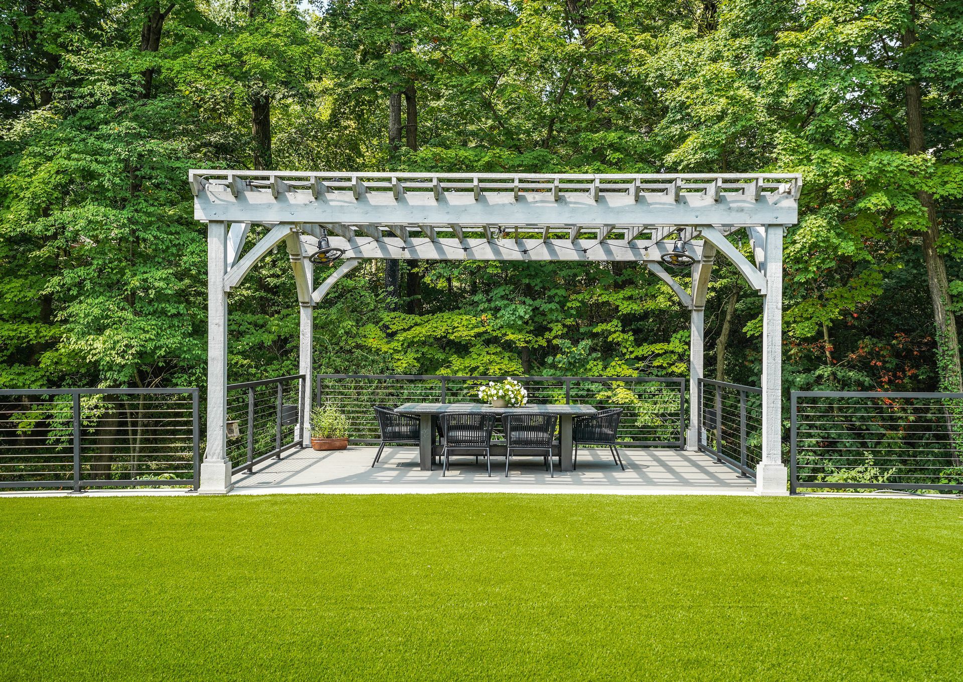 There is a pergola with a table and chairs underneath it.