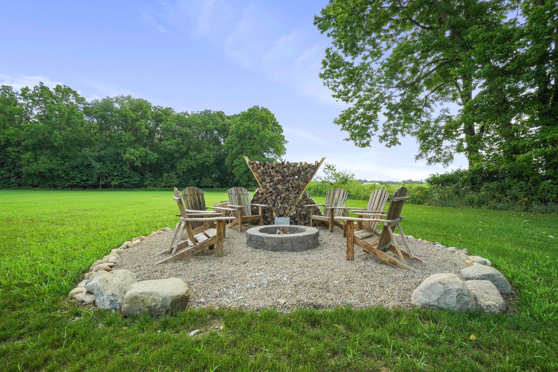 An apartment complex with a pool and lounge chairs on a sunny day. A three-story building sits in the background.