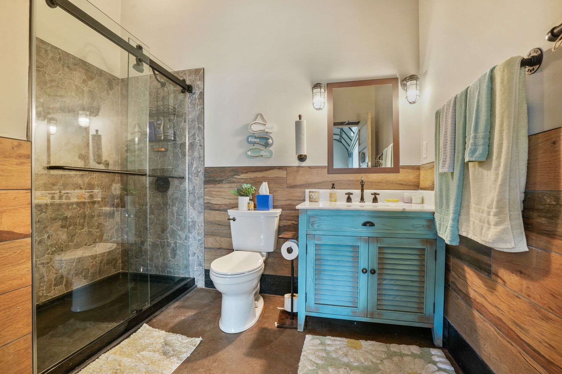 Apartment complex pool area with turquoise water, lounge chairs, and green turf. Buildings surround the pool under a sunny sky.