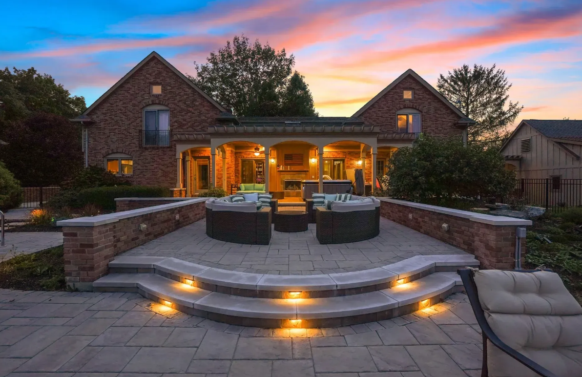 An inviting patio featuring automated outdoor lighting and a cozy seating area.