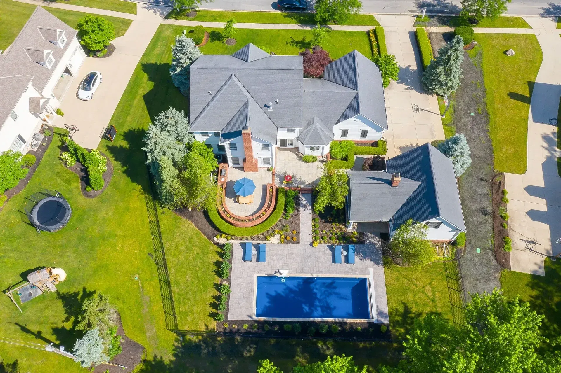 A large swimming pool with water fountains and a gazebo in the background.