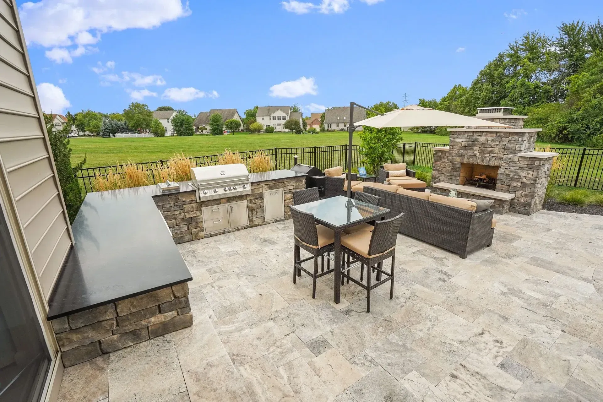 A patio with a table and chairs and a fireplace.