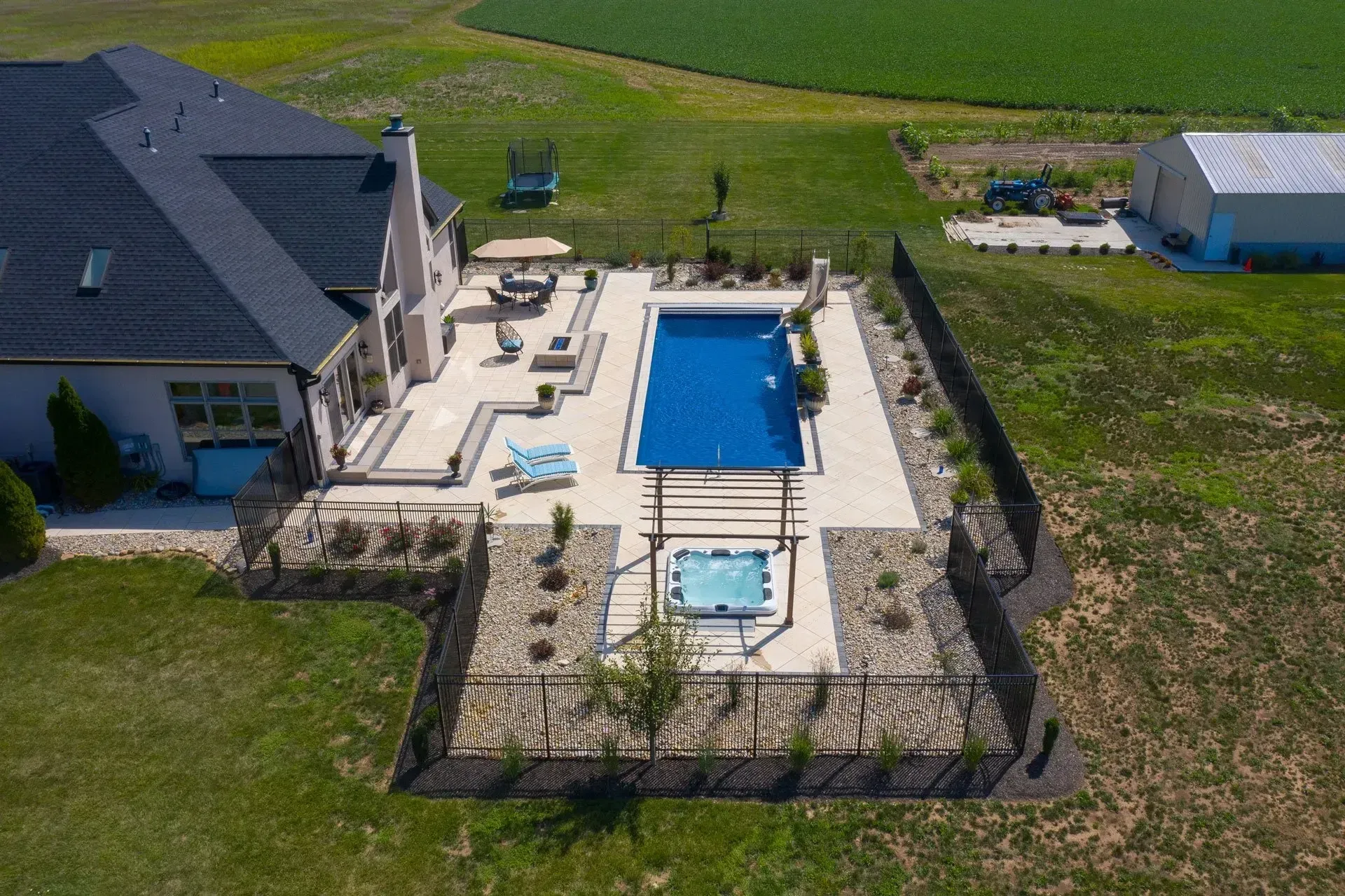 An aerial view of a large swimming pool in the backyard of a house.