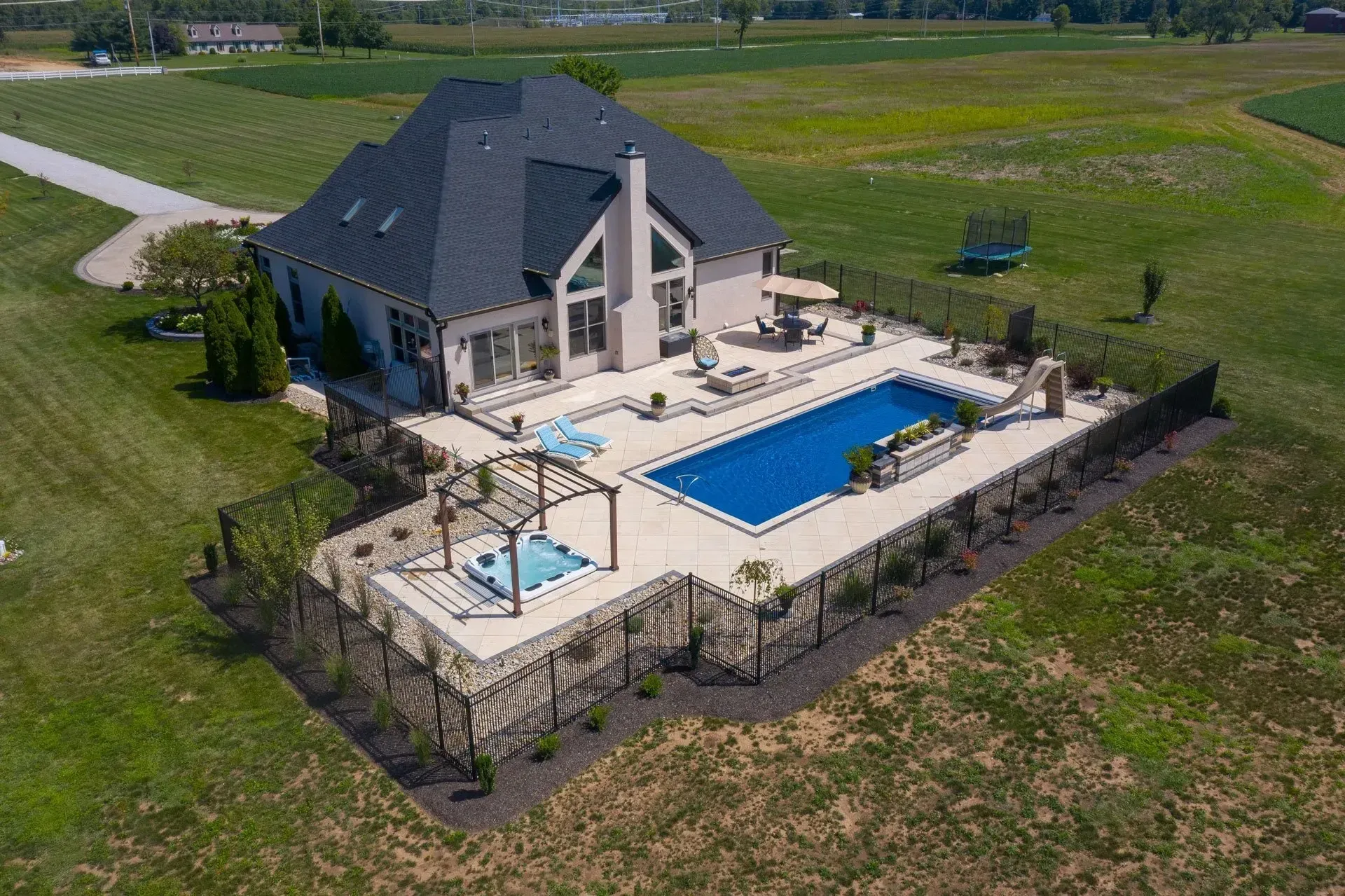 An aerial view of a house with a large swimming pool in the backyard.