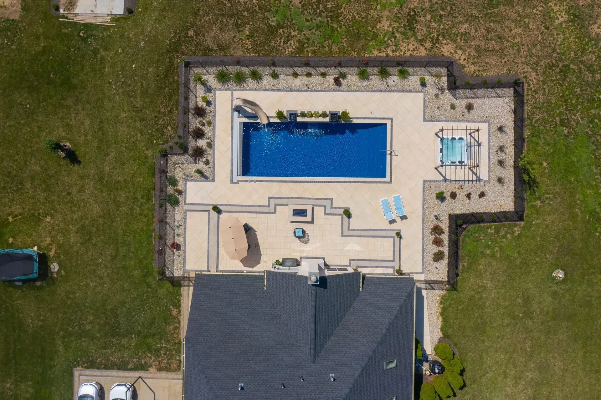 An aerial view of a house with a large swimming pool in the backyard.