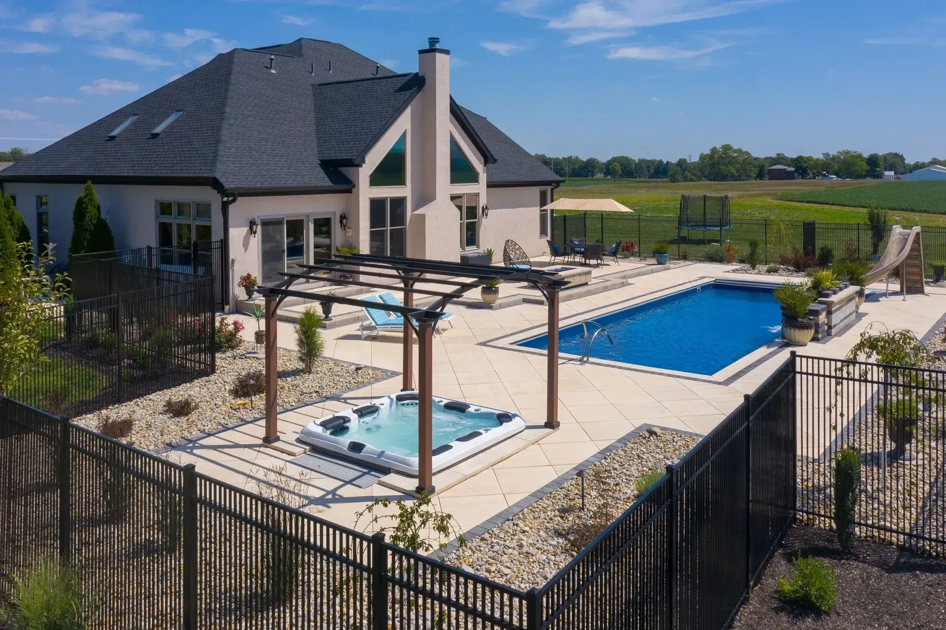 A large house with a large swimming pool and a hot tub in the backyard.
