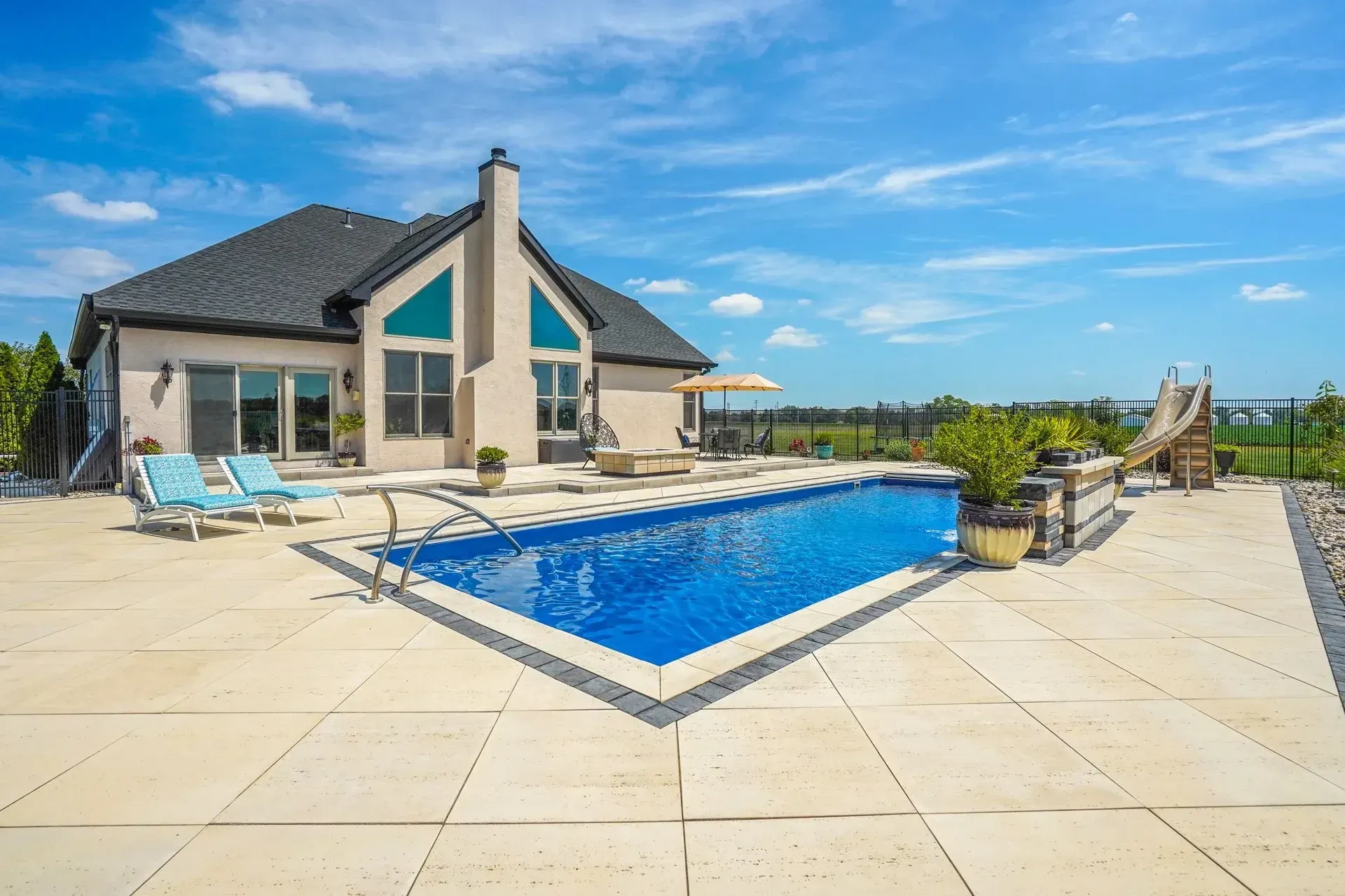 A large house with a large swimming pool in front of it.