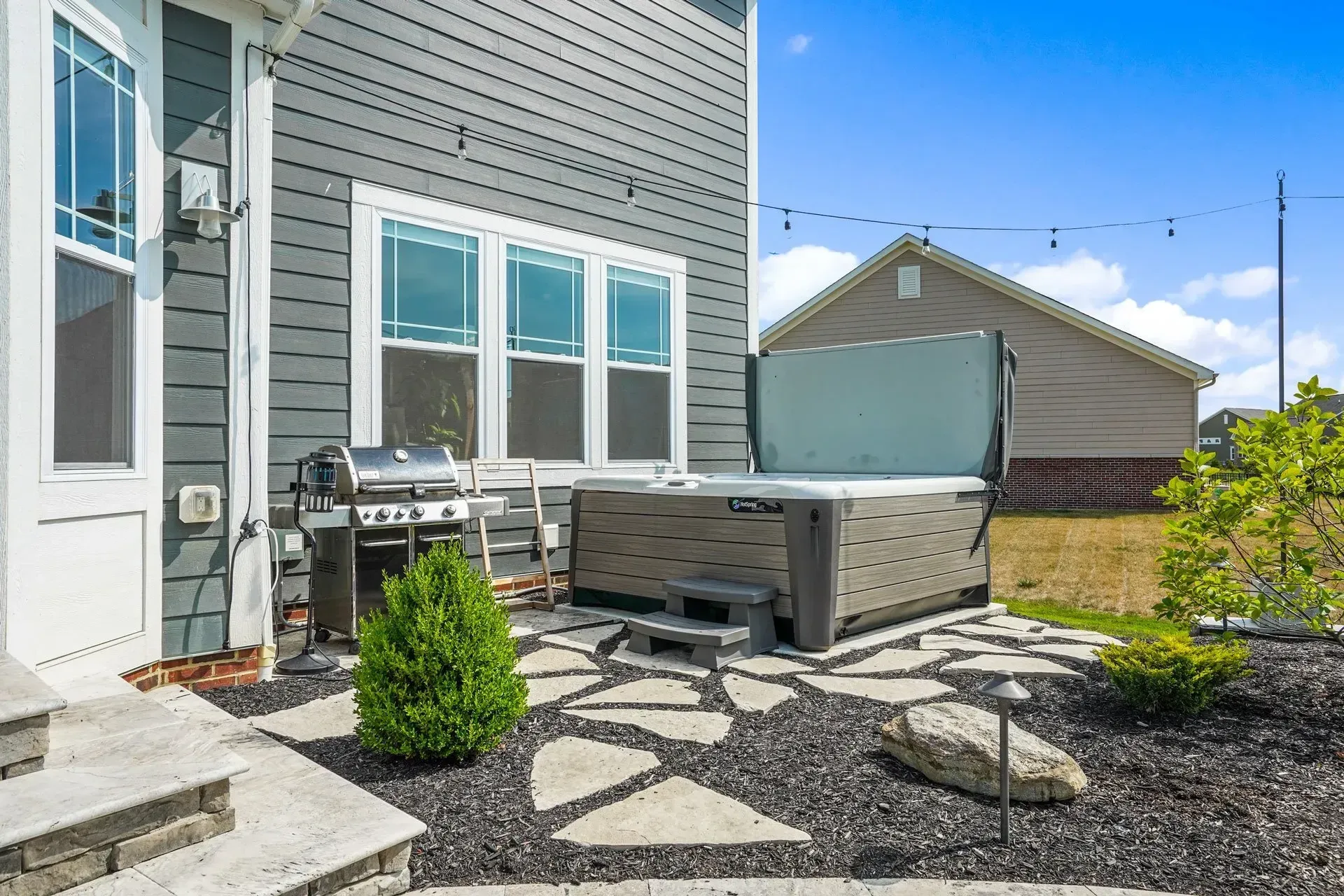 There is a hot tub in the backyard of a house.