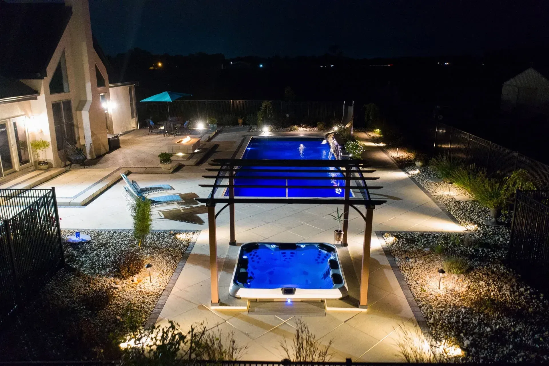 An aerial view of a swimming pool and hot tub at night