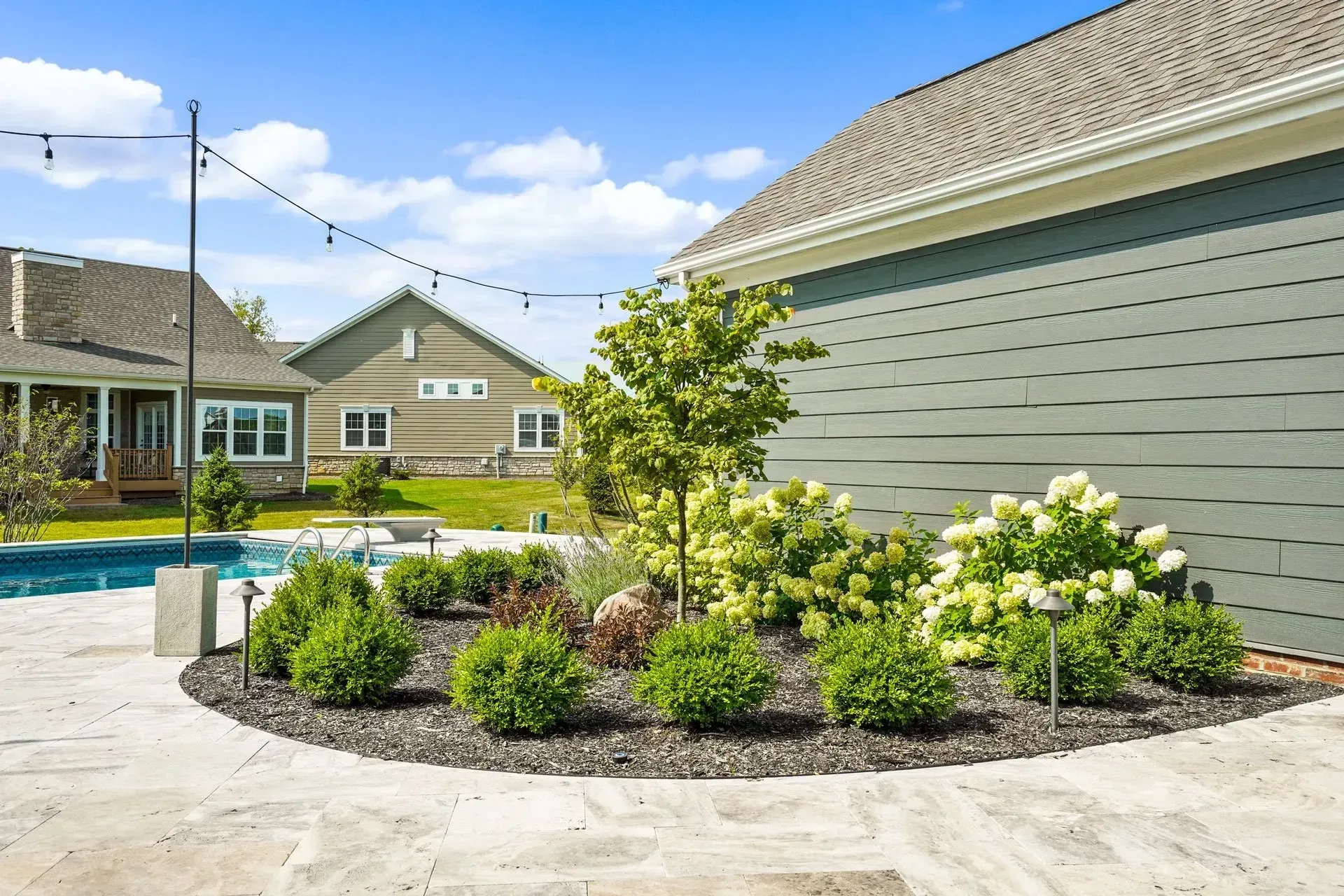 There is a swimming pool in the backyard of a house.
