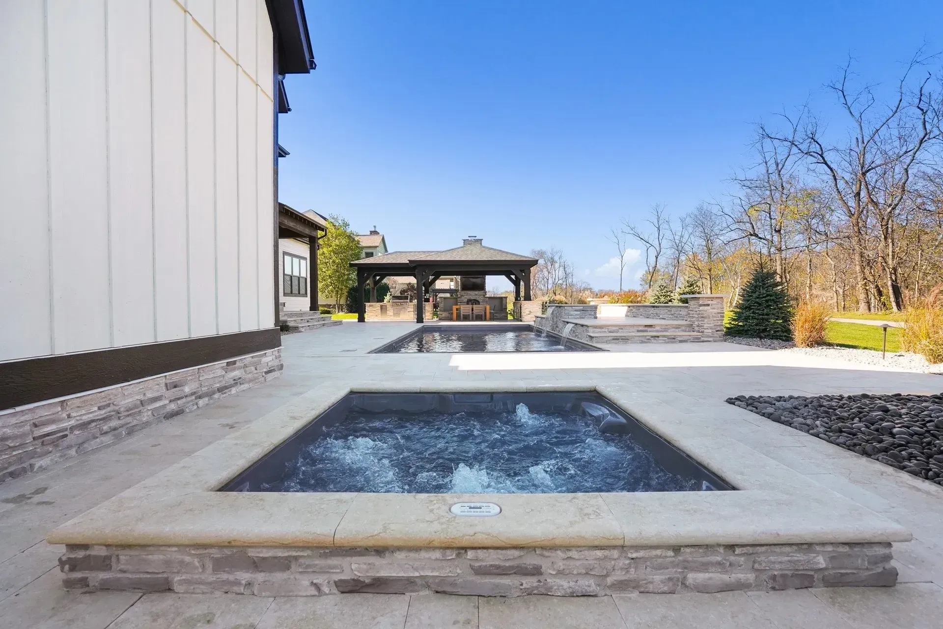 There is a hot tub in the backyard of a house.