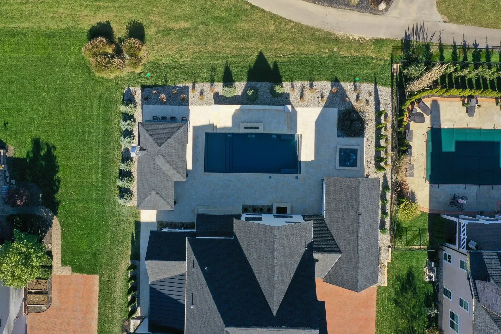 An aerial view of a large house with a swimming pool in the backyard.