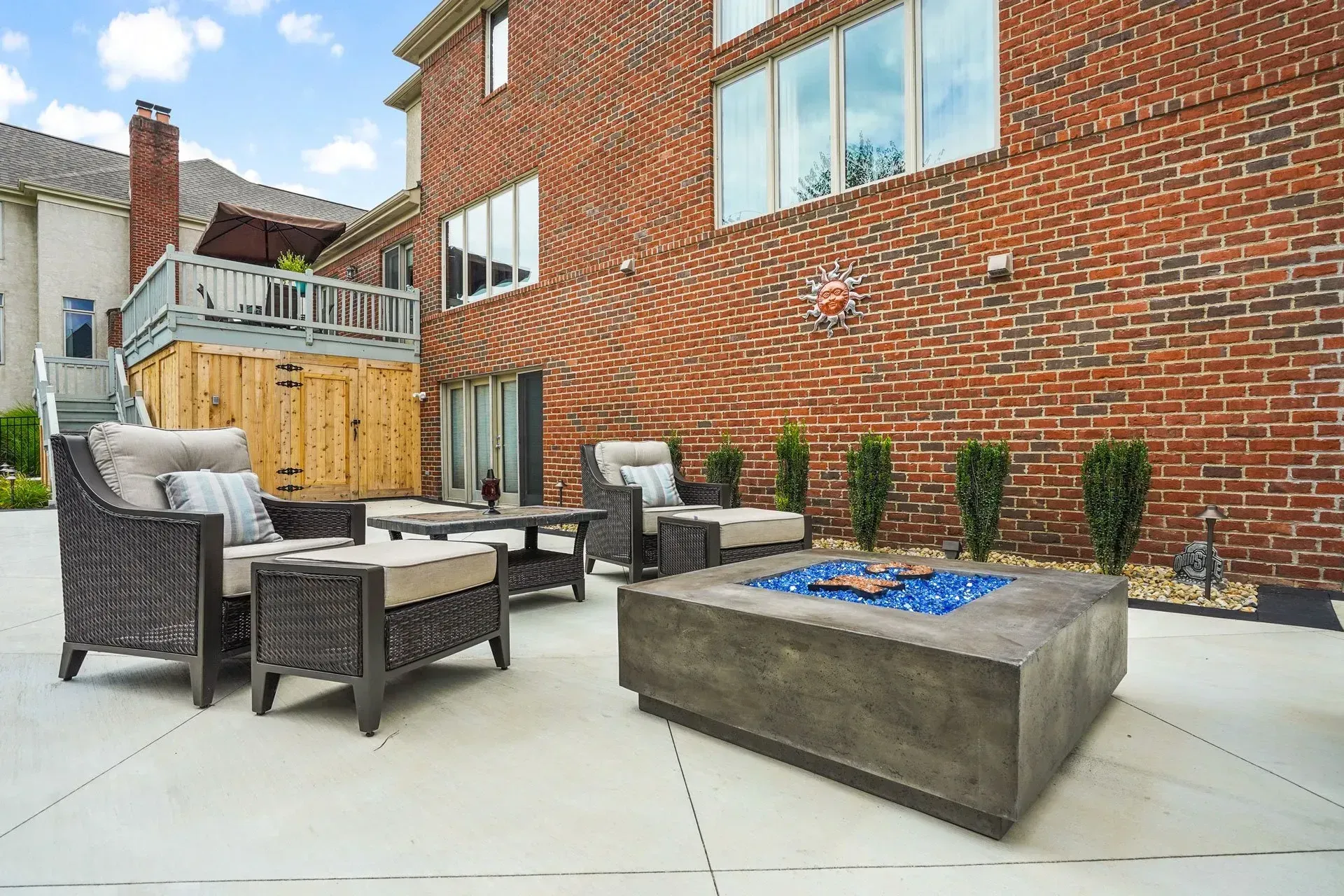 There is a fire pit in the backyard of a brick house.