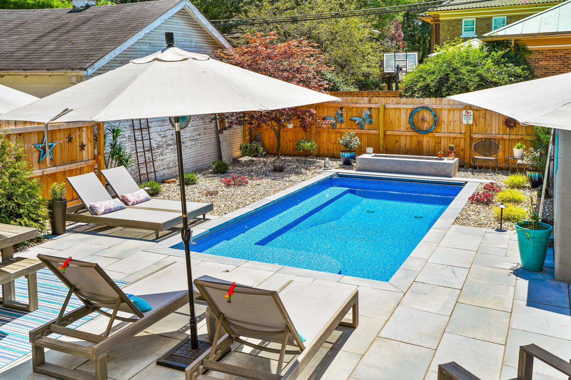 A serene backyard featuring a swimming pool and comfortable patio furniture for relaxation and outdoor gatherings.