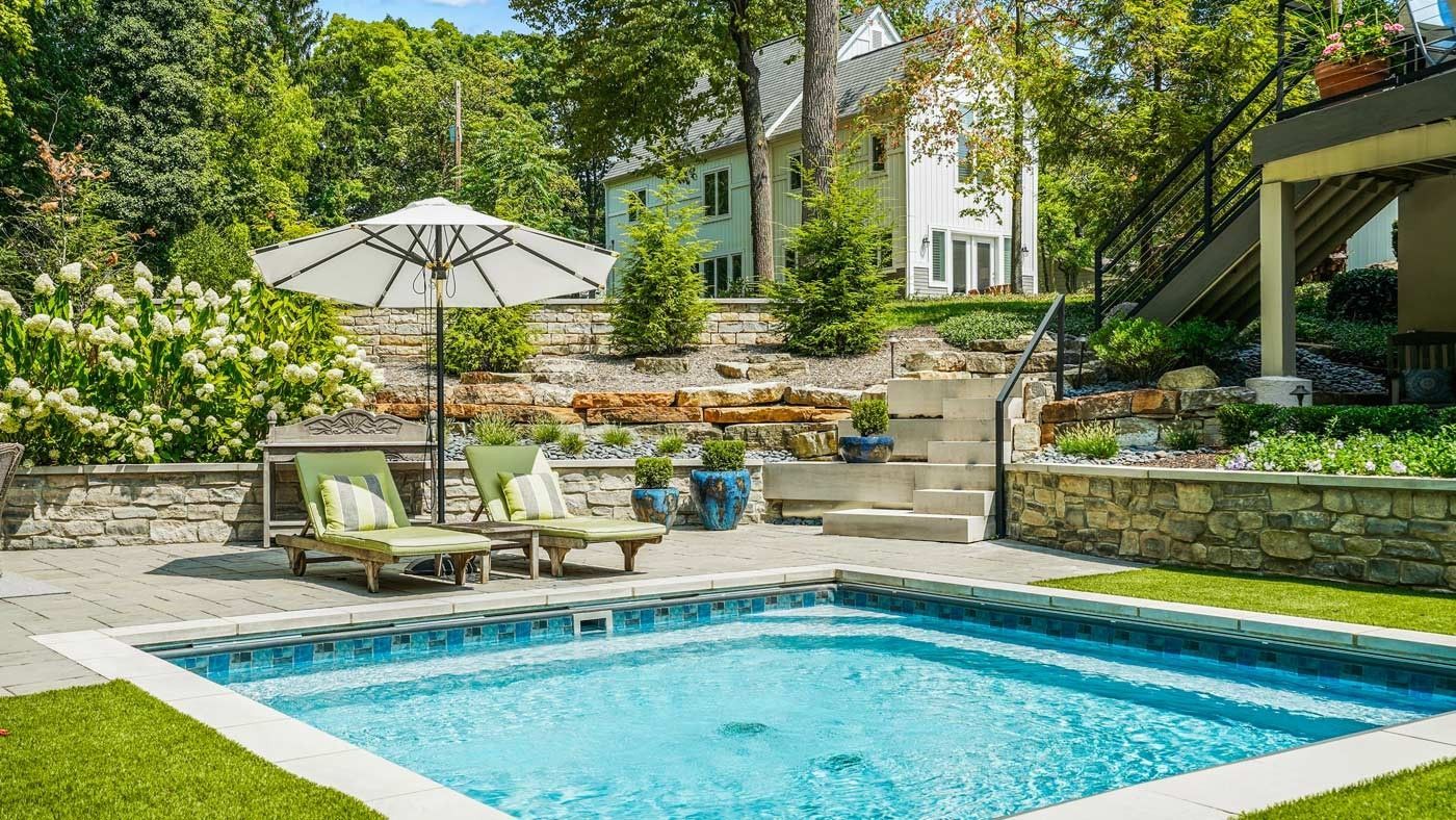 A tranquil backyard oasis with a pool and patio for relaxation and entertainment.