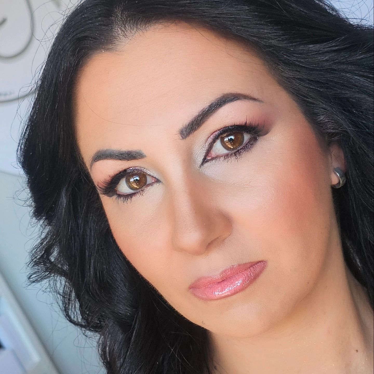 Donna con i capelli scuri, truccata, che guarda direttamente l'osservatore.