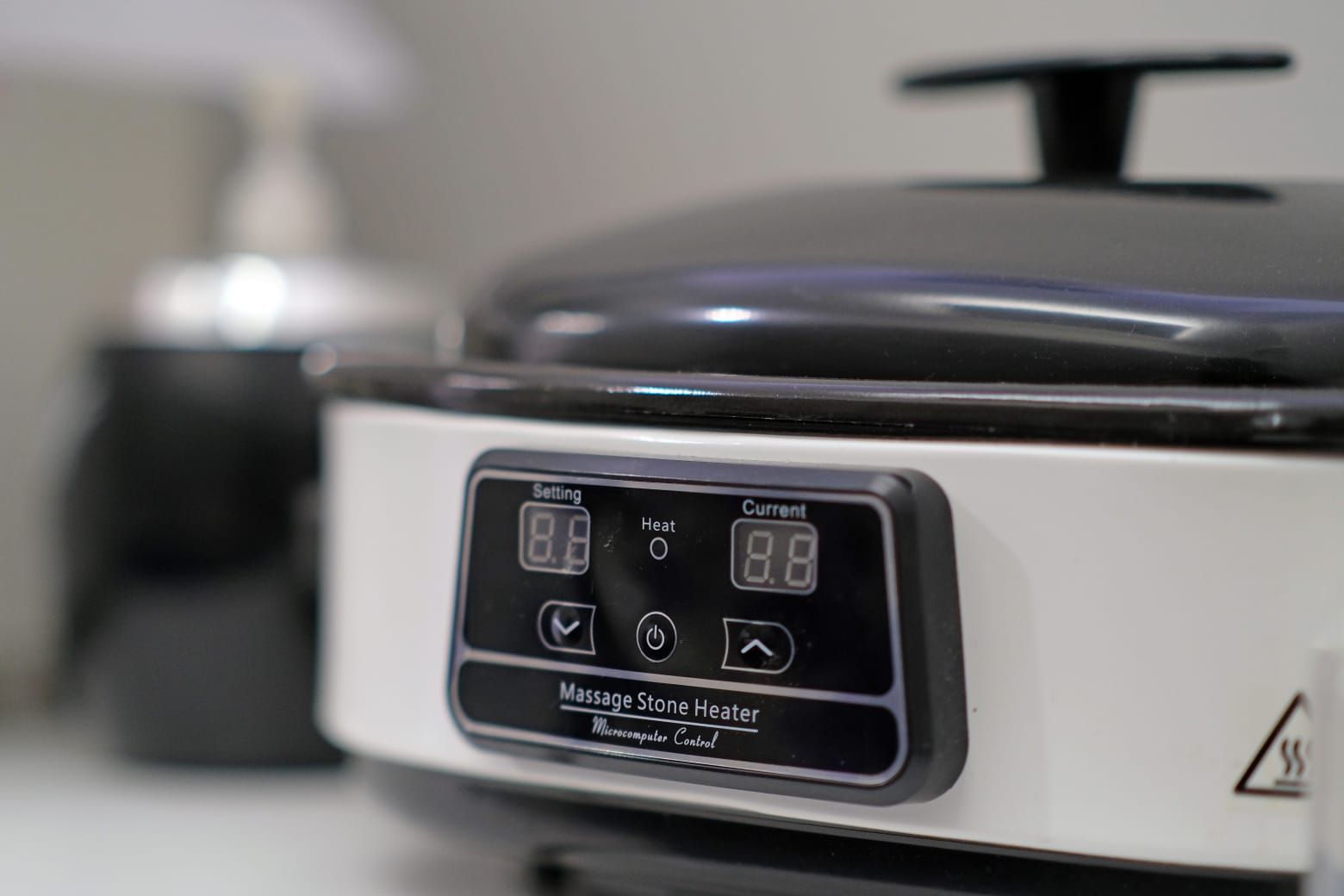 Pentola a cottura lenta bianca e nera, display digitale che mostra le impostazioni, per interni.