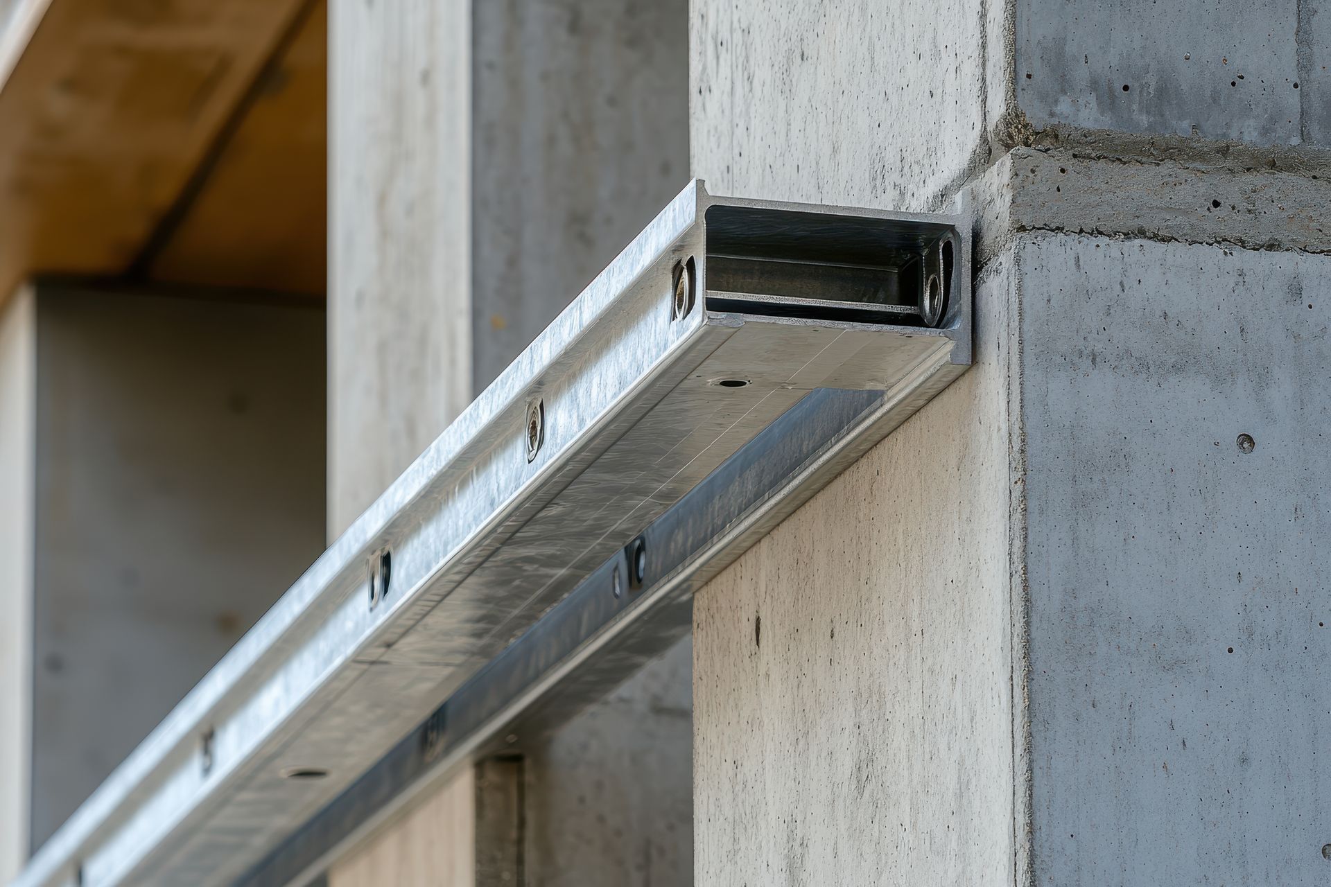 A metal beam is attached to a concrete wall.