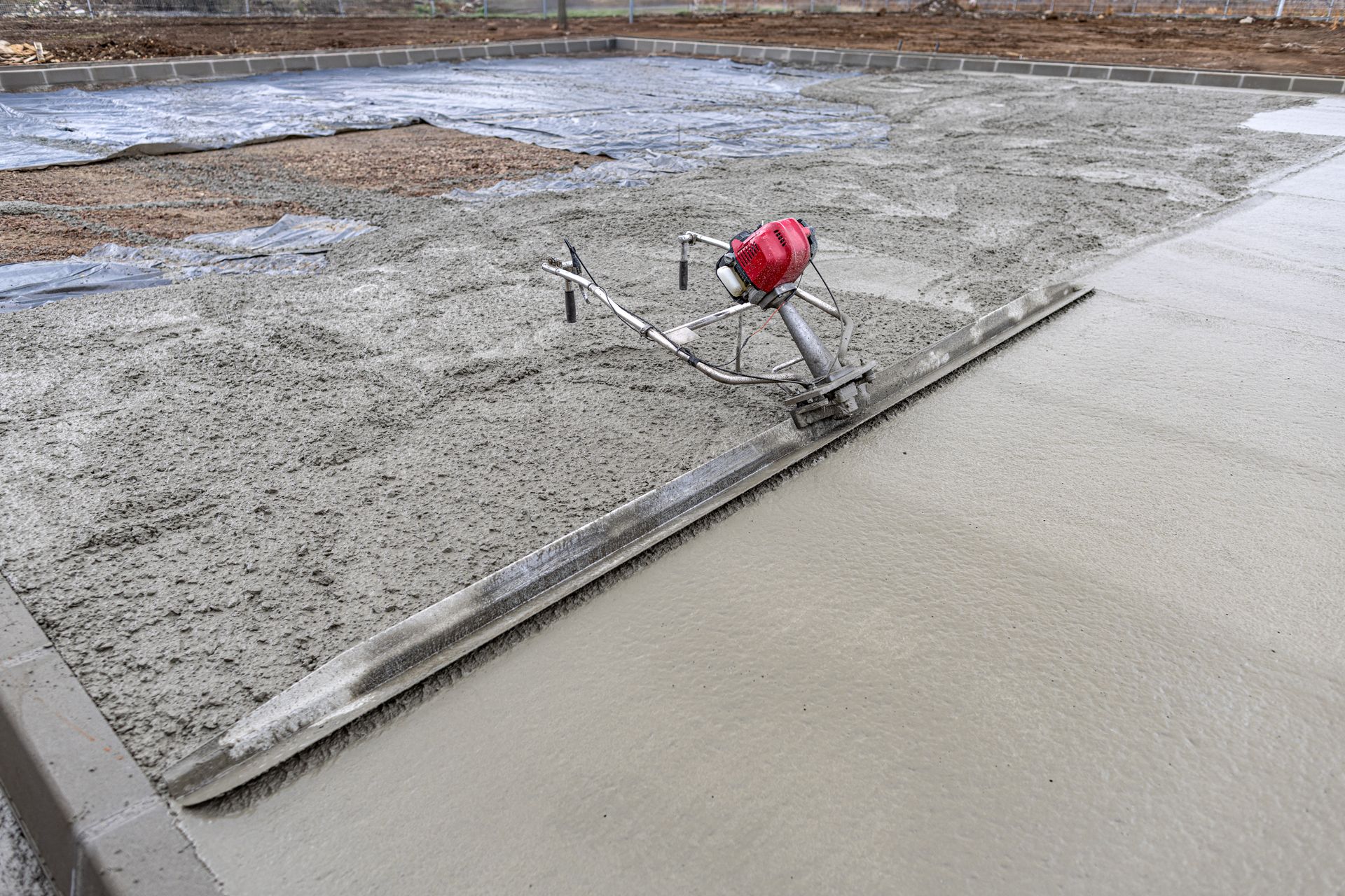 A machine is laying concrete on a sidewalk.