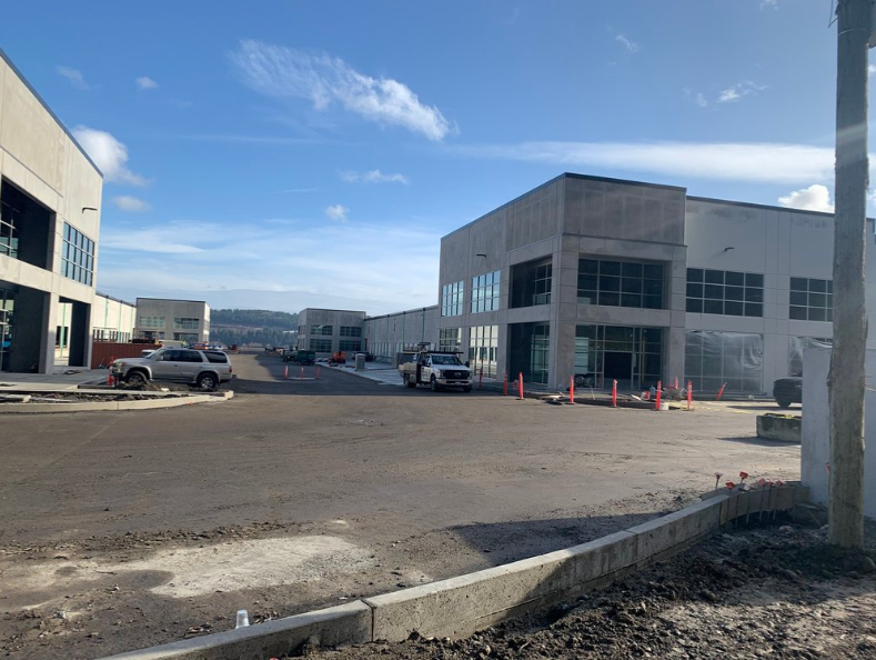 A parking lot with cars parked in front of a building under construction.