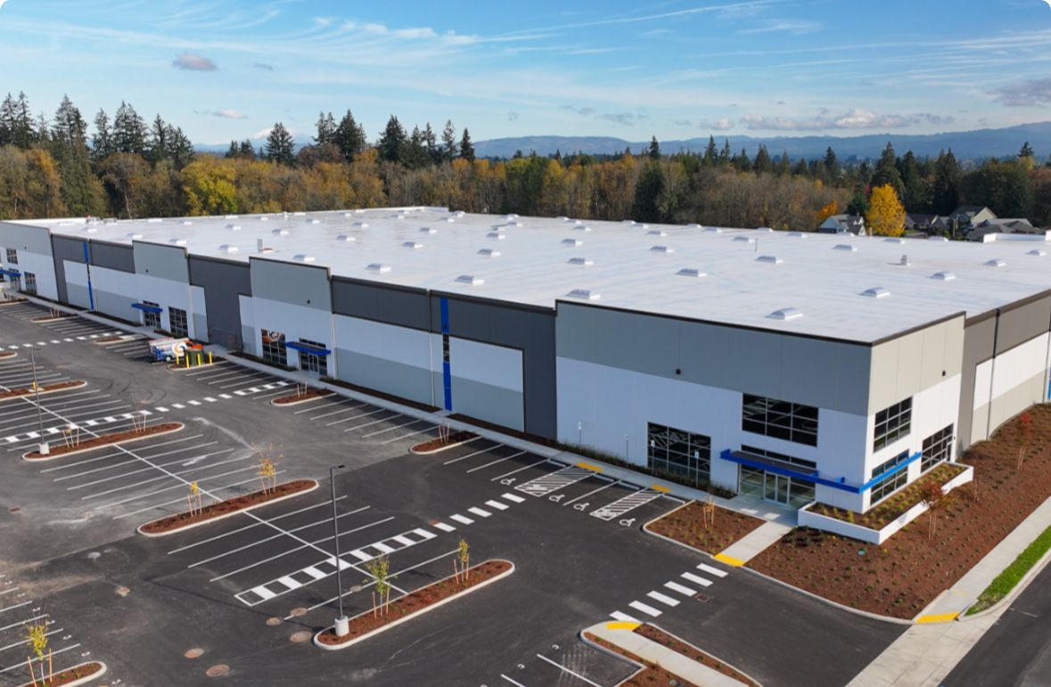 An aerial view of a large building with a parking lot in front of it.