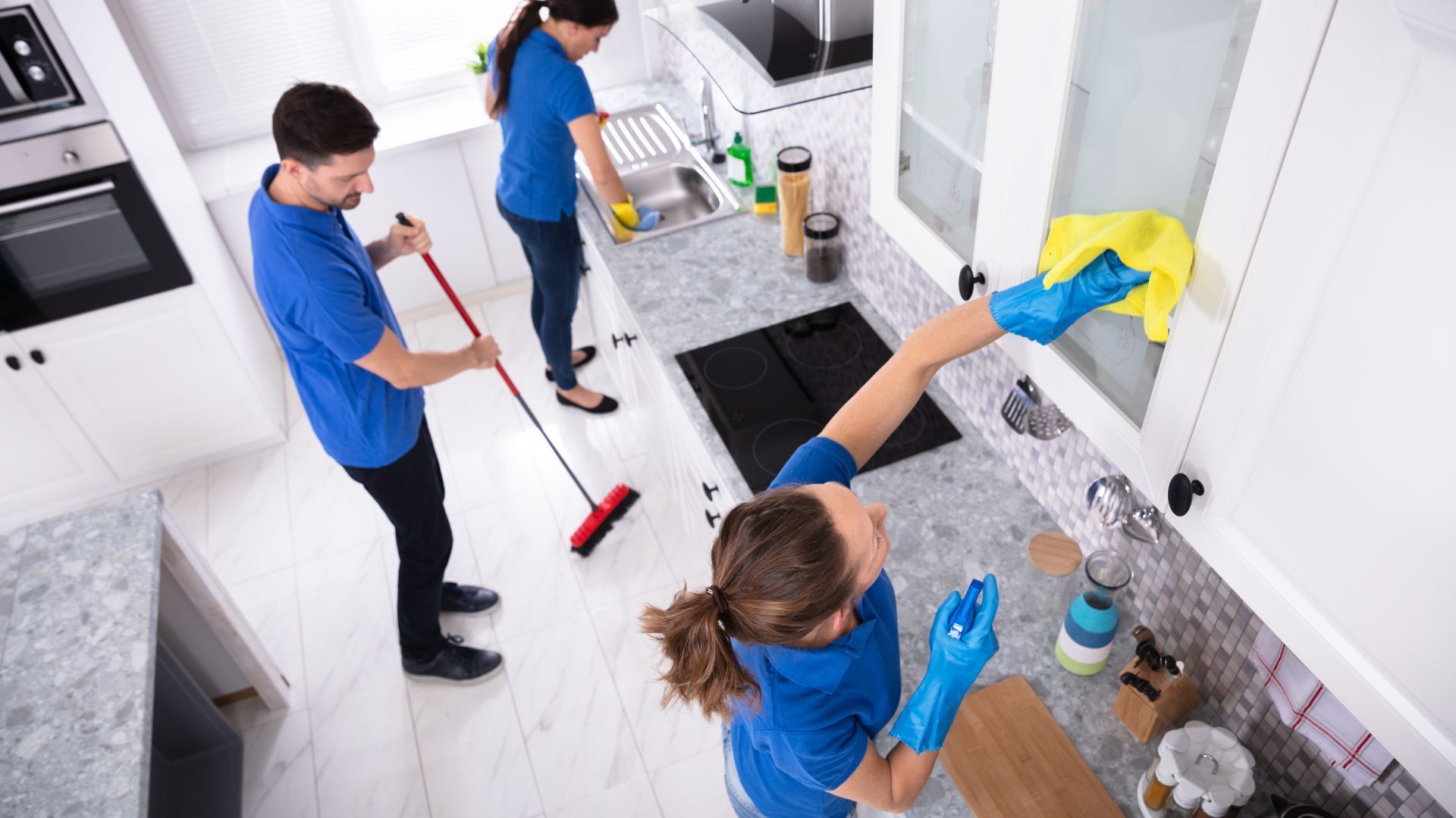 A group of people are cleaning a kitchen.