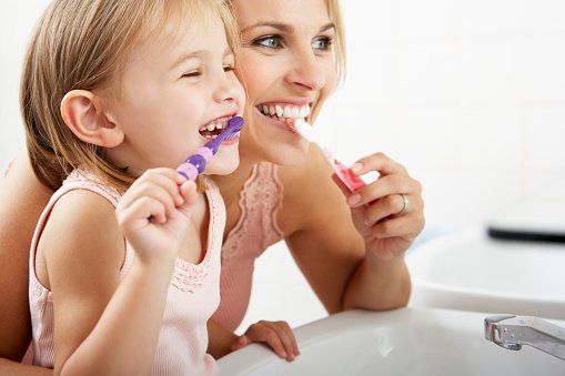 mom and girl brushing teeth
