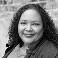 A black and white photo of a woman with her arms crossed