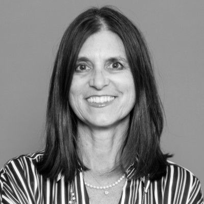 A man in a suit and tie is smiling in a black and white photo.